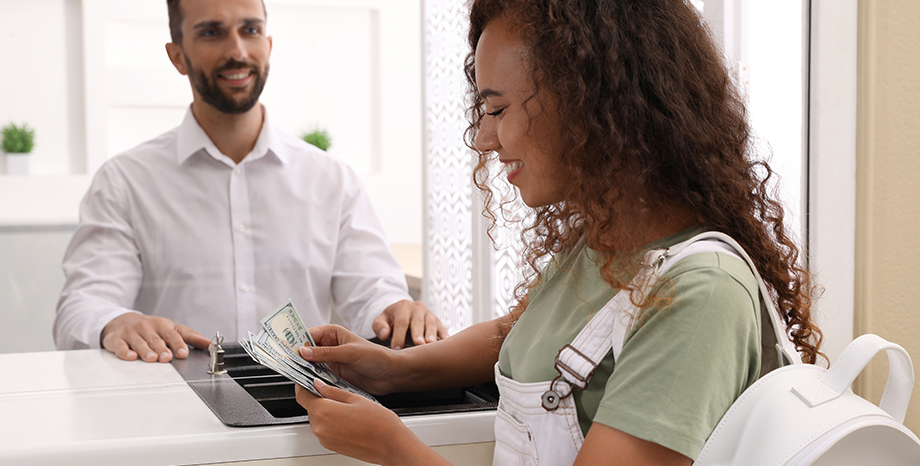 woman receiving cash from teller at bank