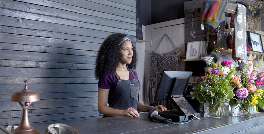 Female business owner interacts with retail point-of-sale solutions at her flower shop