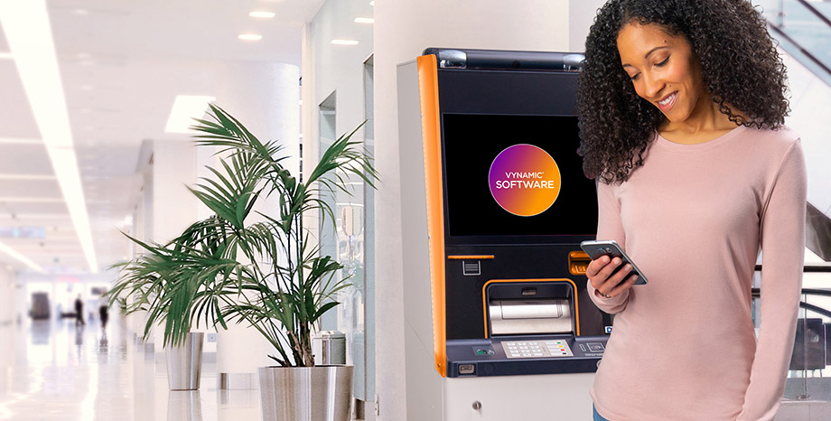 woman on smart phone in from of DN Series ATM