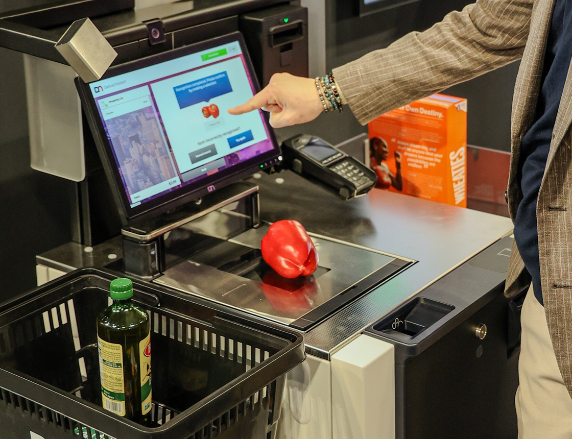 hand selecting a red pepper on self checkout screen