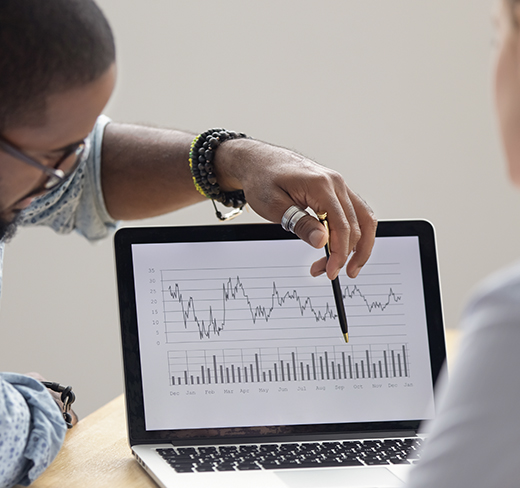 2 employees looking at a graph on a laptop